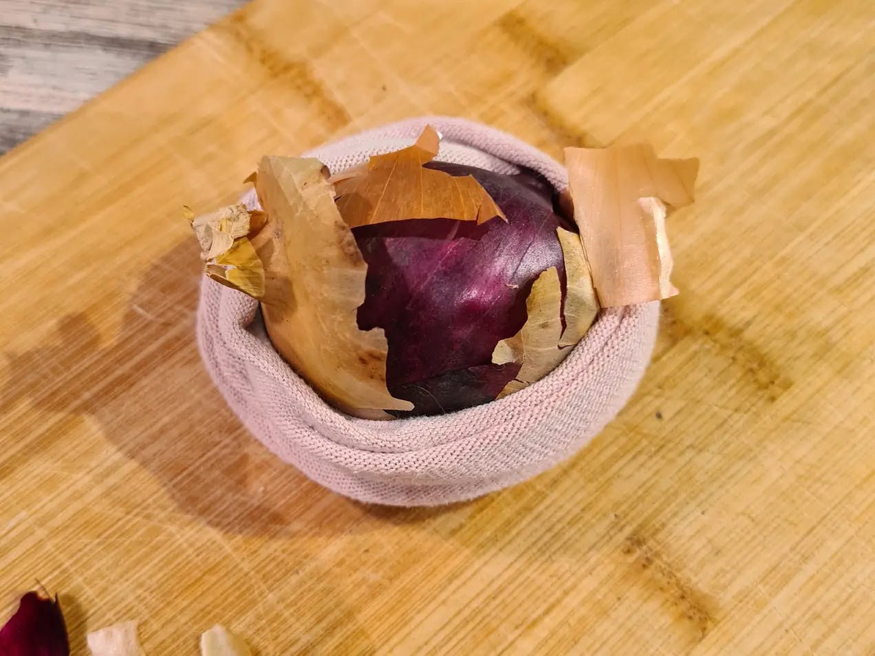Egg pakket inn i løkskall og en sokk. Fotografi