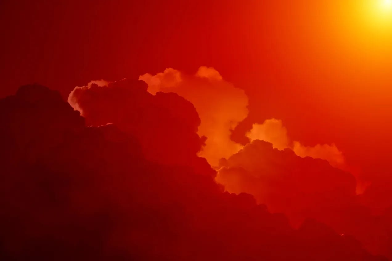 røde skyer med en gul sol øverst i høyre hjørne