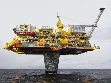 Oljeplattformen Draugen står på en betongstolpe ute i havet. Fotografi